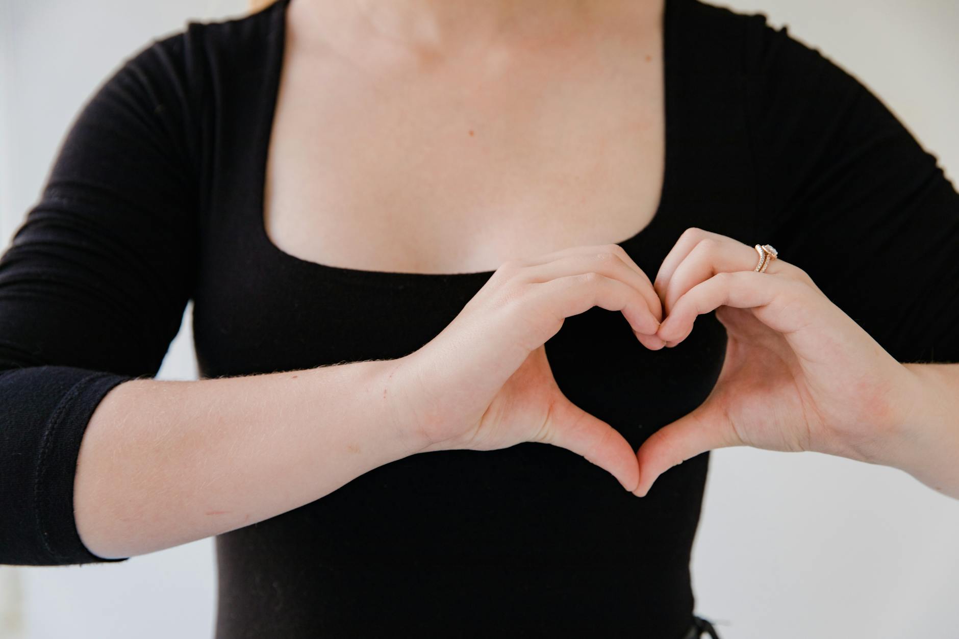 close up on woman making heart sign