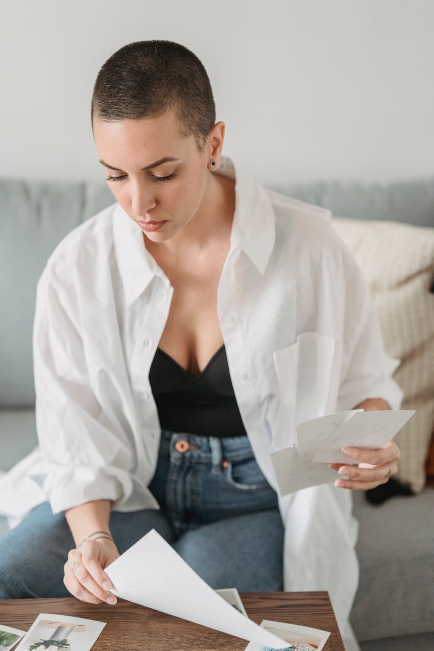 woman choosing photos at table in house room